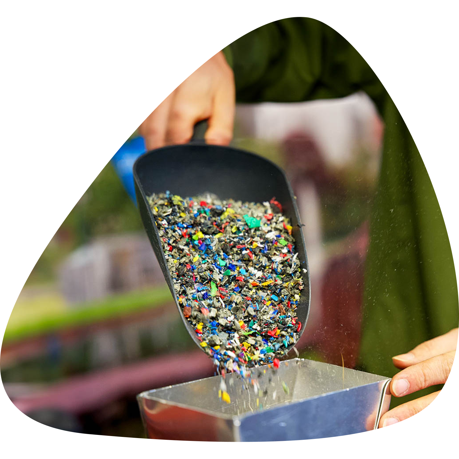 Close up of plastic granulate being placed into a machine in a plastic waste recycling plant 